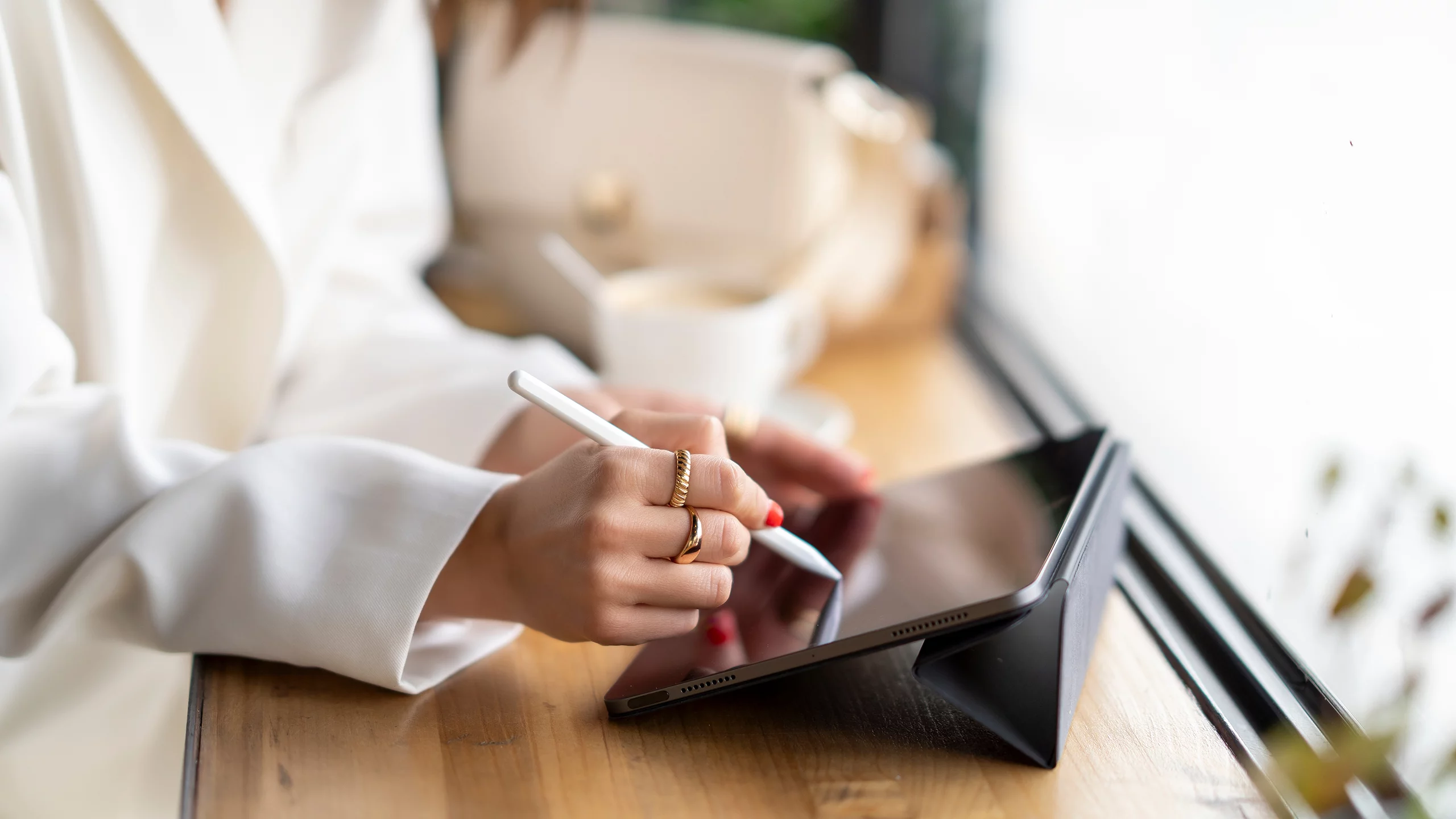 Eine Frauenhand benutzt einen Touch Pen auf einem digitalen Tablet
