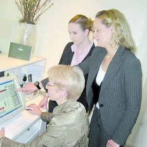 Drei Mitarbeiter vor einem PC